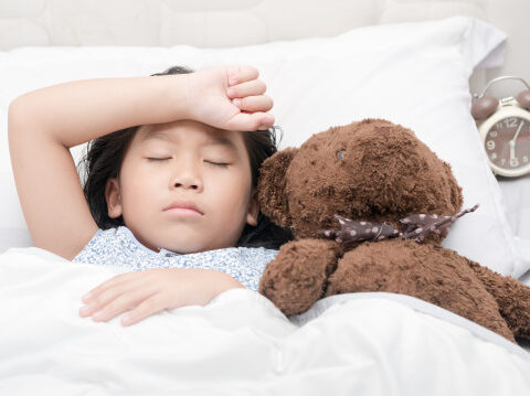A little girl sleeping beside her stuffed toy